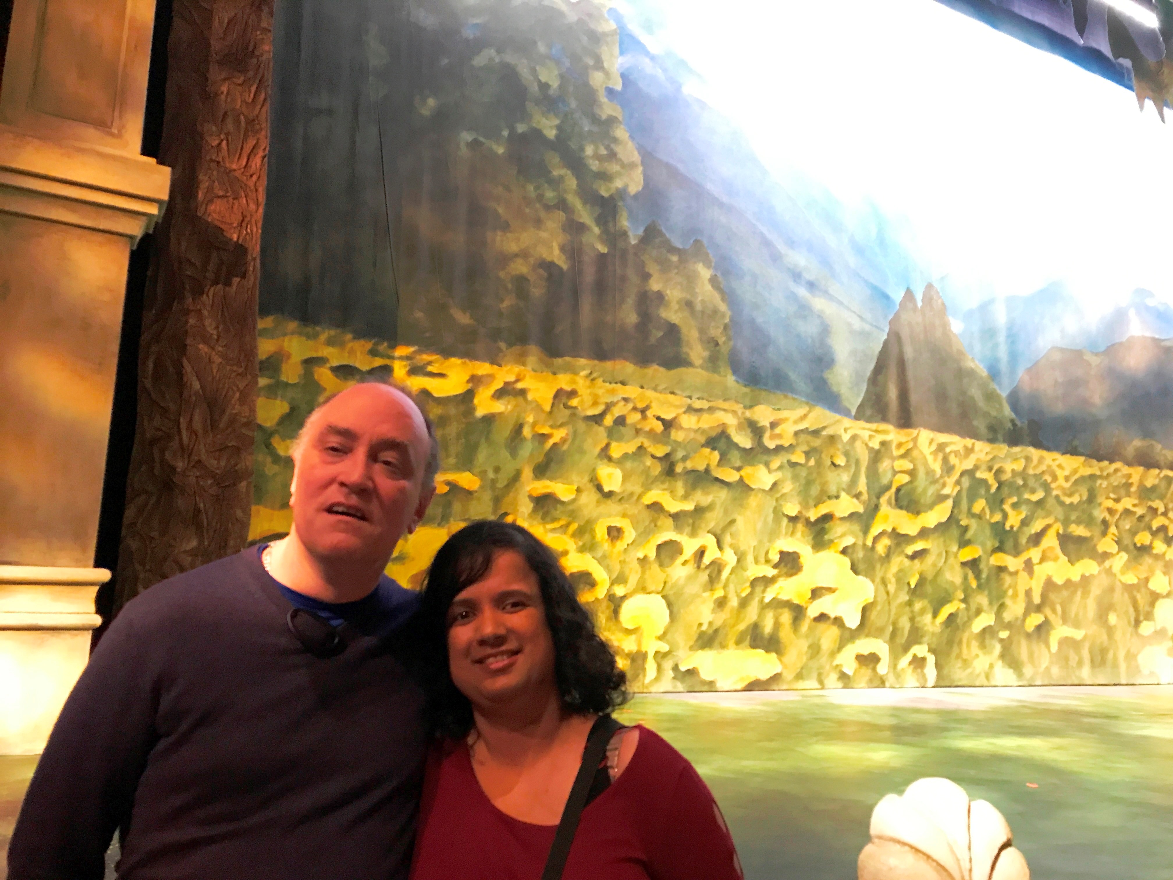 Kristy and Shawn at intermission, with green foliage and foggy mountain peaks behind them